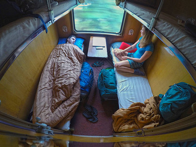 男和女背包客在凉爽的卧铺火车旅行时休息图片