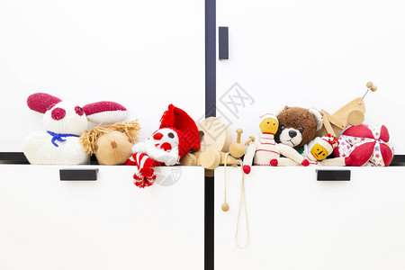 衣柜抽屉里有趣的老式儿童玩具的正面图品种包括小丑松鼠娃球泰迪熊木图片