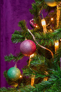 以紫色主题装饰圣诞树并配有突出的装饰吊图片