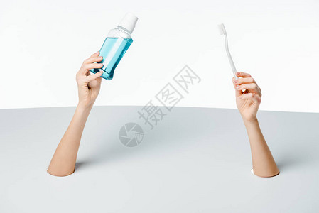 女人拿着牙刷和漱口水穿过白色洞的短片图片