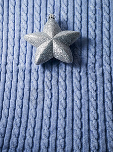 蓝编织布背景的银色圣诞明星背景图片