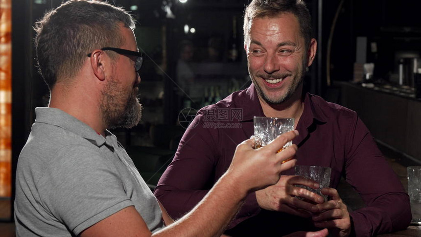 两个朋友一起喝酒时对着镜头笑有胡子的成熟男人和他英俊的朋友喜欢喝威士忌友谊休闲图片