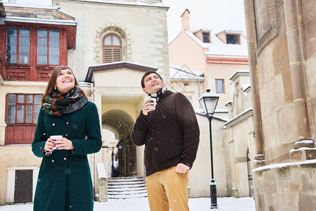 年冬在老城漫步喝热茶和咖啡的年轻情侣图片
