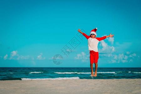 快乐的小男孩享受欢庆圣诞节在热带海滩度假图片