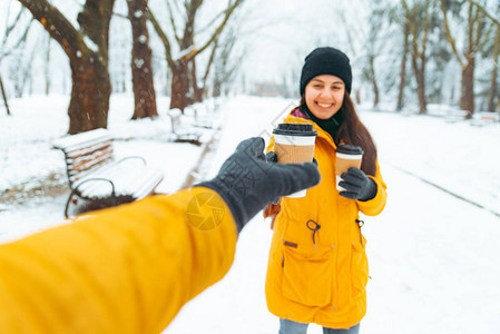 女人给朋友喝咖啡在雪地冬图片