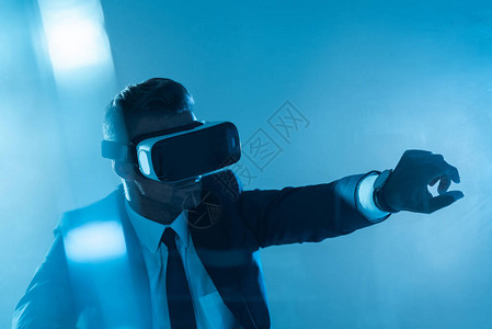 商业在虚拟现实头盔上触摸一些孤立的东西在蓝色图片