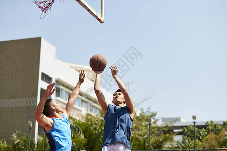年轻的篮球选手在户外法庭上击图片