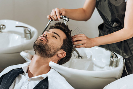 美容院男客户的理发员洗发给男客户的一图片