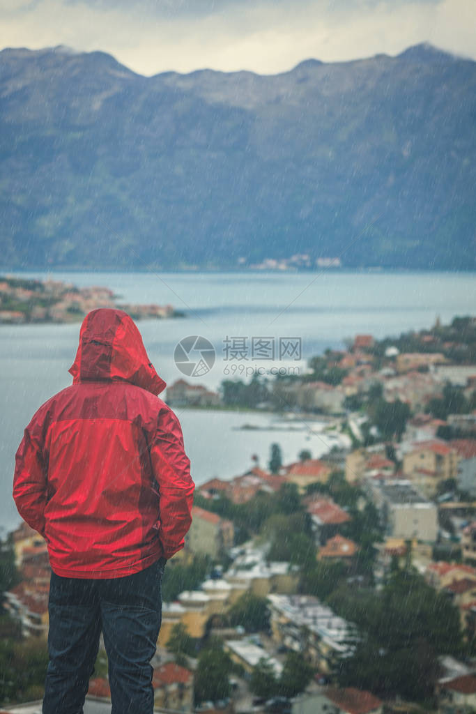 身穿防水红色夹克的人站立在望台上图片