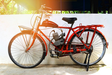 旧摩托车自行车老式自行车红色墙上经典引擎自行车在图片