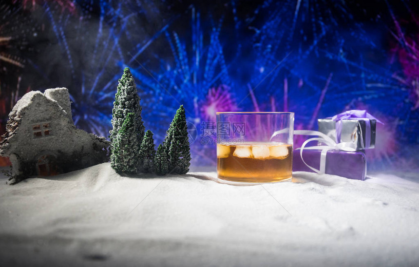 玻璃与威士忌在雪地上与艺术品圣诞装饰一杯威士忌在白雪上与美丽的假日背图片