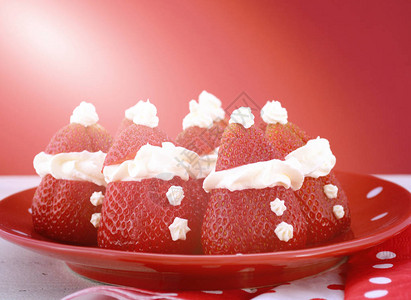 圣诞节日派对食品草莓圣诞老人在红色和白色波尔卡盘上图片