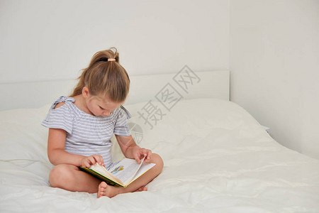 坐在家里床上看童话故事读书的可爱图片