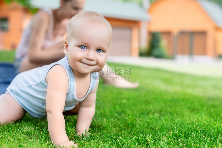 可爱的白人小男孩和妈在花园里玩的画像孩子在院子里和妈一起散步时在绿草地上爬行快乐的童图片