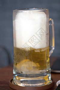 木制桌上满杯新鲜啤酒在透明玻璃中酒图片