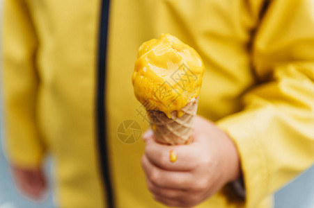一个孩子拿着黄色芒果冰淇淋的特写图像图片