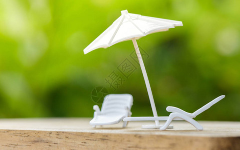 销售保险概念或计划在假期放松在自然绿色背景下为家庭在长椅上保护伞财产安全白色伞背景图片