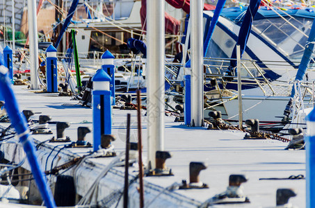 游艇游艇和机动船的特写镜头停泊在港口炎热的一天和码头的蓝水图片