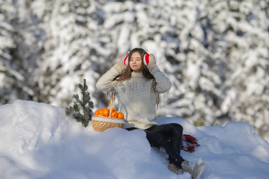 一个年轻女孩在冬季森林散步带着一篮子的普通话在图片