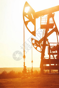 抽油机在日落背景的油田工作背景图片