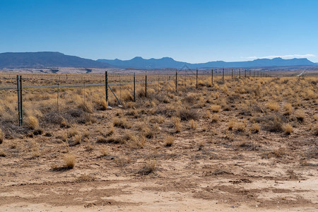 新墨西哥州沙漠农田沿线的铁丝网栅栏使动物远离道路阳光夏日孤图片