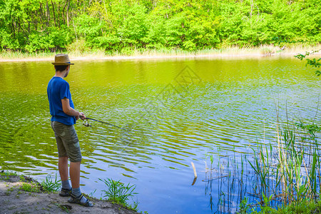 夏天在风景如画的河上钓鱼的轻帽子的家伙图片