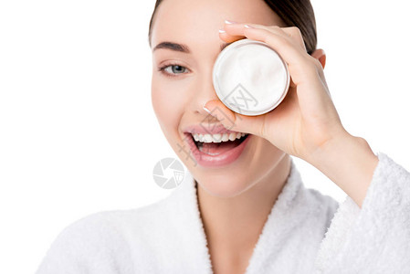 穿着浴衣的笑着女人在脸前拿着湿润奶油霜图片