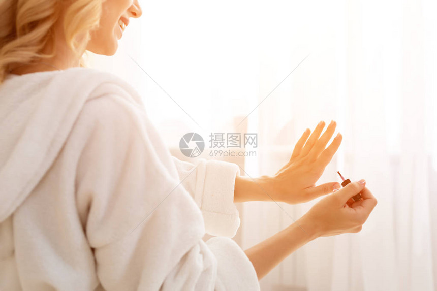 一个身材匀称的女人早上画指甲的特写图片