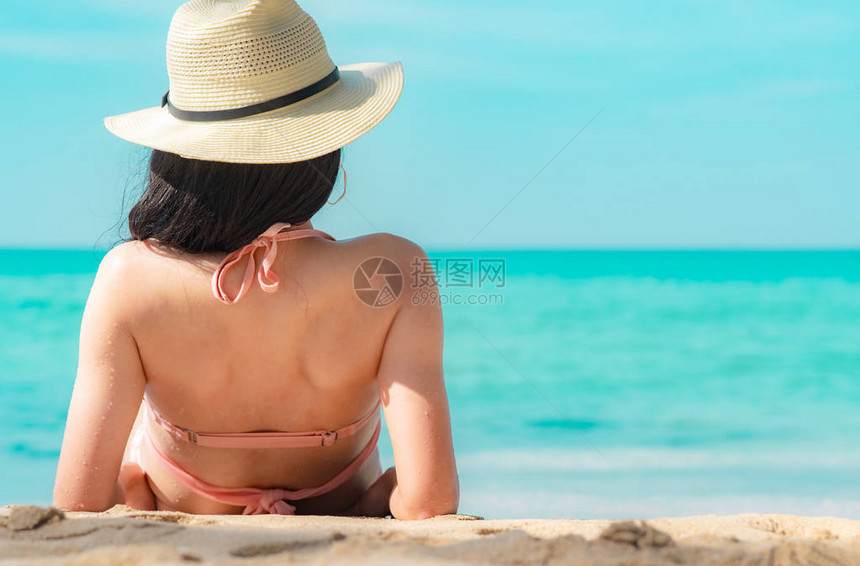 身穿粉色泳衣和草帽的快乐亚洲年轻女背影在日落时分在热带天堂海滩放松和享受假期暑假时尚的女孩美女感模特优图片