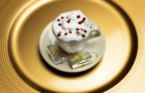 圣诞咖啡加奶油和陶瓷碟上的小礼图片