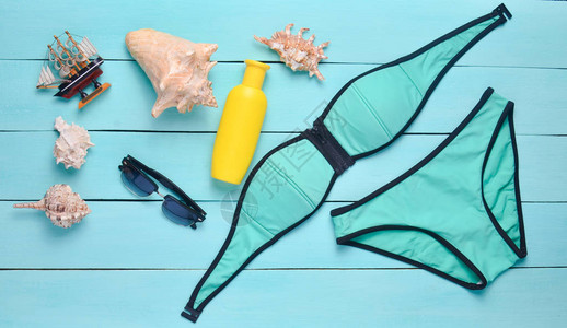 泳衣防晒霜贝壳蓝木板上的太阳墨镜图片