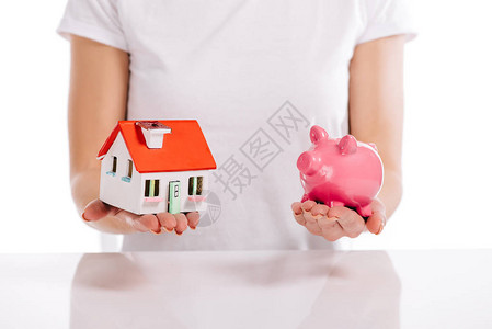 妇女拥有住房模式和在白房贷概念上孤立的小猪银行图片