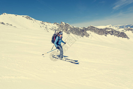 女野外滑雪者在陡峭的斜坡上滑雪图片