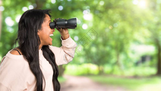 年轻的美国女青年在户外与望远镜看远图片