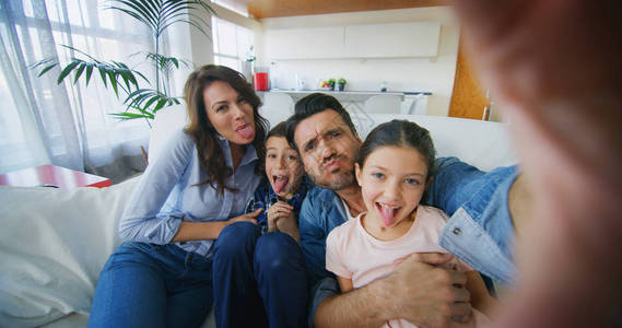 幸福的家庭在客厅以慢动作自拍的肖像沟通联系技术生活方式社会图片