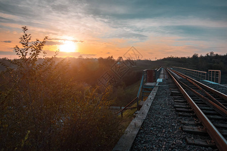 铁路轨沿多彩日落背景的图片