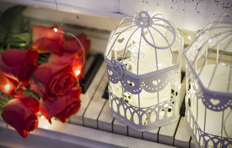 白钢琴上的红玫瑰上面有笔记和装饰图片