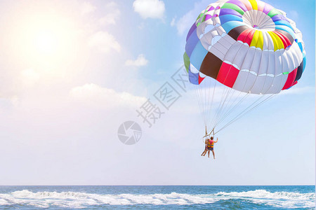 在度假胜地的海边暑假乘船降落伞在游艇后面飞图片