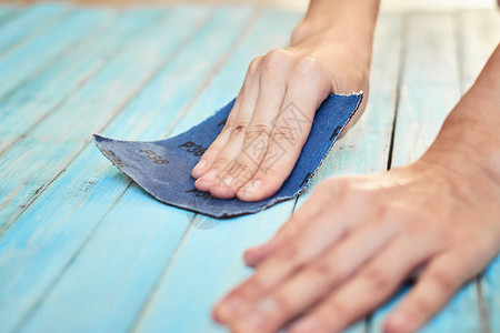 用砂纸打磨木板的手图片