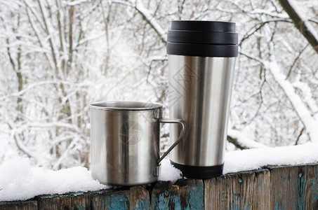 铁杯和热咖啡或茶的保温杯寒冷的冬日在森林里圣诞假期图片
