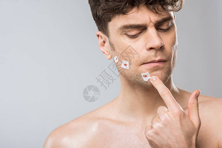 帅哥在刮胡子后摸脸被灰色隔离图片