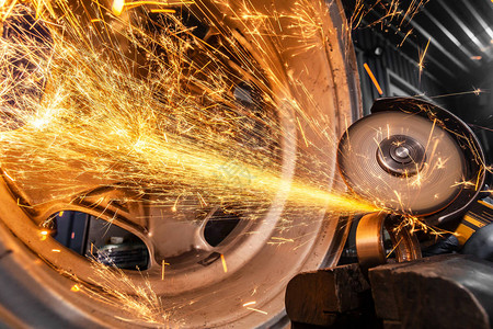汽车修理工使用金属磨床在汽车修理厂切割轴承的特写镜头背景图片