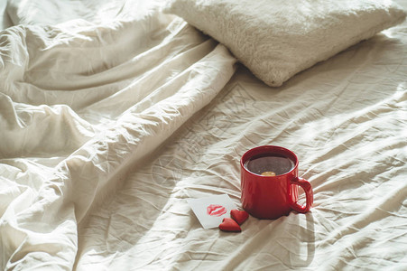 红茶杯和两个红茶和两个心饼干白床上一张图片