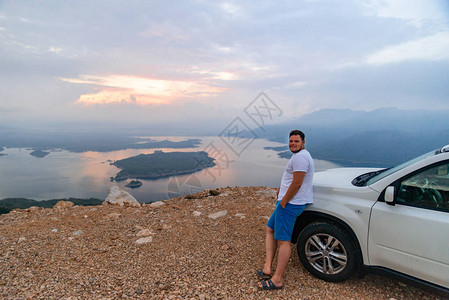 站在悬崖上的人靠近汽车看着湖面的日出公图片
