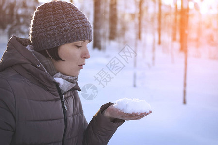 女人在手掌上吹雪图片