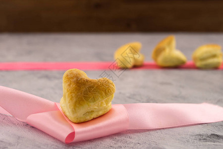 粉红丝带上的心形饼干情人节礼物浅薄背图片