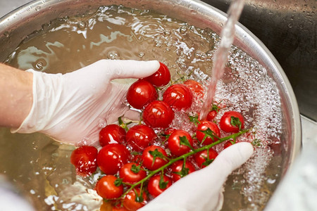 厨师把樱桃西红柿浸泡到水中番茄图片