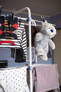 灰色的泰迪熊和玩具在洗完衣服后挂在干燥的衣服图片