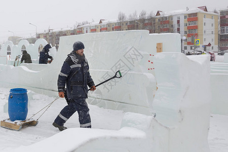 一个人在冰镇上带着雪橇一桶水图片