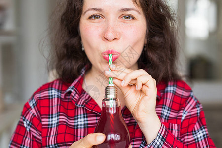 健康食物饮食和人的概念年轻妇女在瓶子里喝天然汁图片